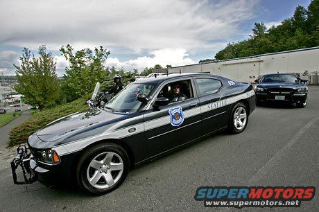Black and white police car with "SEATTLE POLICE" text, angled from the front-left