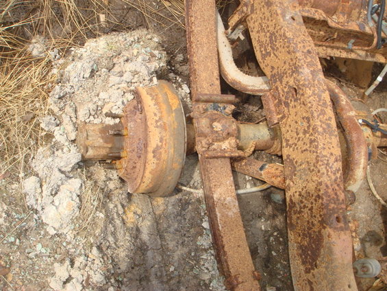 rusted rear axle drum brake assembly and leaf spring on the ground
