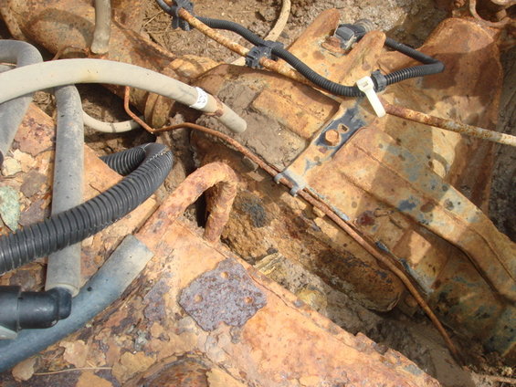 Rusted vehicle undercarriage with hoses and wiring
