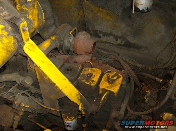 Engine block with turbocharger, oil filter, and yellow painted components. Wires and hoses are visible