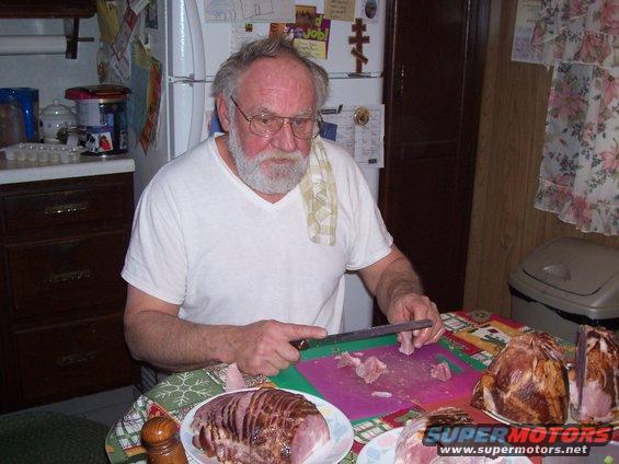 Man carving ham in a kitchen
