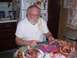 1992 Ford Bronco - A man with a beard carves a ham in a kitchen setting, with other hams visible on the table.
