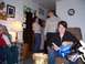 1992 Ford Bronco - People gather in a living room, with a dog present. One woman sits in a chair holding some papers.