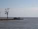 1992 Ford Bronco - People and a car are gathered on a pier overlooking the water on an overcast day.