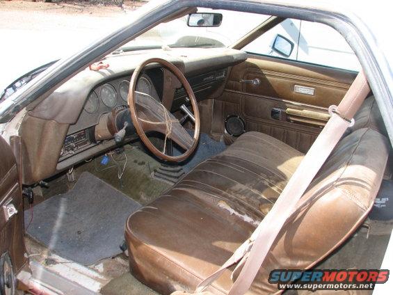 1973 Ford Ranchero interior showing brown vinyl seats, dashboard with gauges, and wooden steering wheel