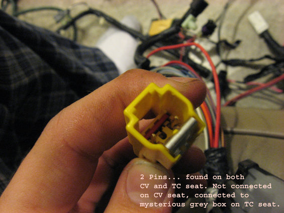 Yellow electrical connector with two pins and red and grey wires, held by a hand. Text overlay mentions CV and TC seats