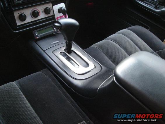 Car's center console with gear shifter, climate controls, and digital display