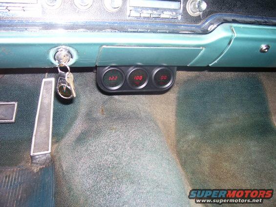 Aftermarket gauges showing 122, 100, and 00 installed below dashboard with keys in ignition