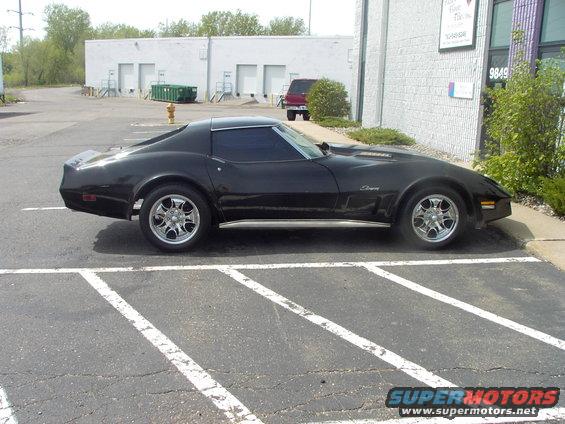 Black coupe parked in a lot, side view