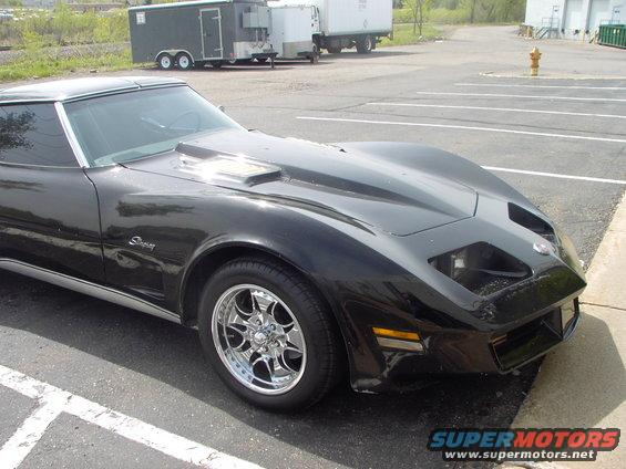Black Chevrolet Corvette C3 with hood scoop and aftermarket wheels