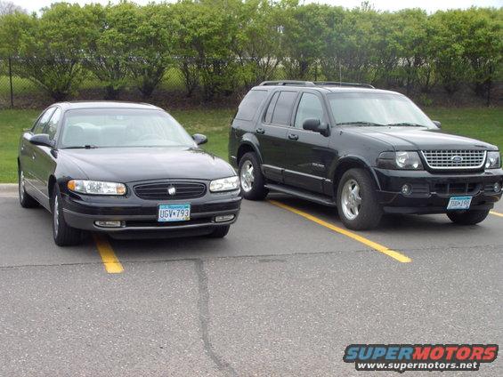 Black Ford Explorer and a black Buick Regal parked side-by-side in parking spots