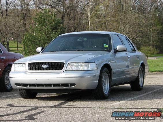 Silver 2003 Ford Crown Victoria parked next to a maroon car