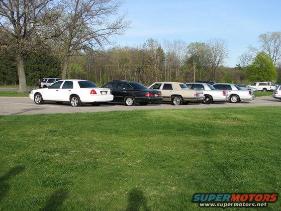 White 2003 Ford Crown Victoria sedan, rear view, parked in a lot