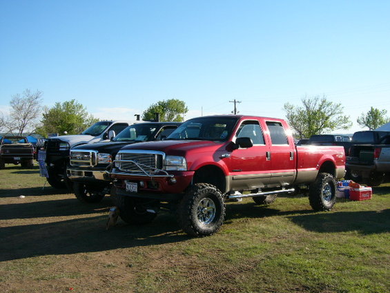 Red lifted pickup truck with chrome grille and large tires