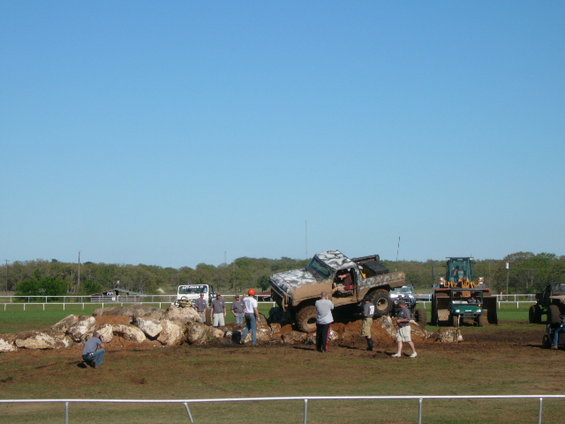 1978 Ford Bronco with camouflage paint climbing rocks, driver visible