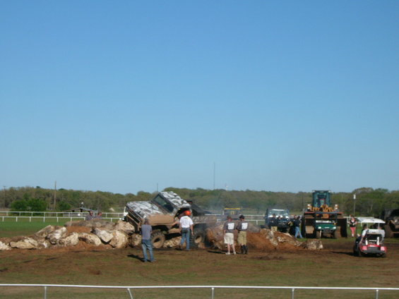 Off-road vehicles on a rock obstacle course with spectators. One vehicle is a 1979 Ford Bronco