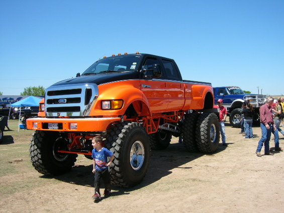 Orange and black lifted Ford F-650 truck with large tires