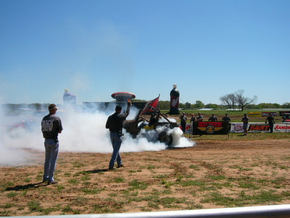 Jeep doing a burnout, emitting thick smoke, with a Confederate flag flying