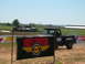 1978 Ford Bronco - A vintage pickup truck is seen doing a burnout on a dirt track, with a banner in the foreground.