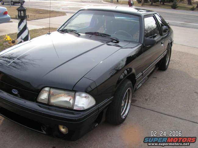 Black coupe parked on a driveway, front quarter view. Date stamp says 02.24.2006