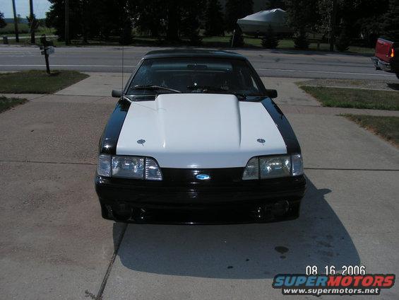 Black and white Ford Mustang with aftermarket hood, front view