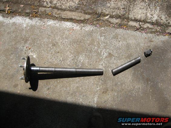 Broken axle shaft with flange and separate pieces on concrete