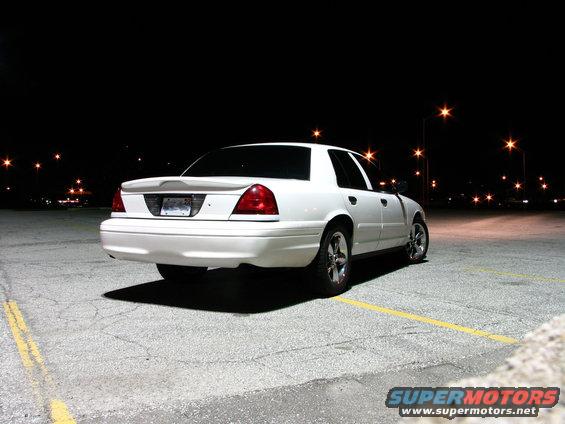 White 2003 Ford Crown Victoria parked at night, rear 3/4 view