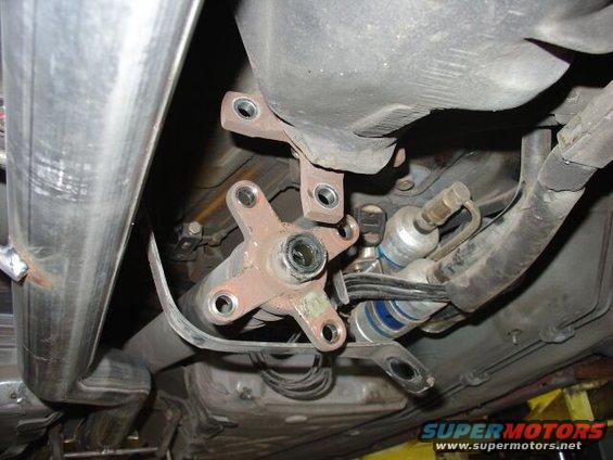 Driveshaft U-joint and fuel filter assembly underneath a vehicle