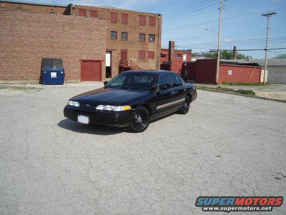 Black sedan parked in front of a brick building