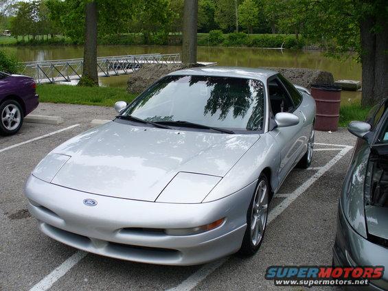 Silver 1991 Ford Probe parked next to a purple car and a gray car