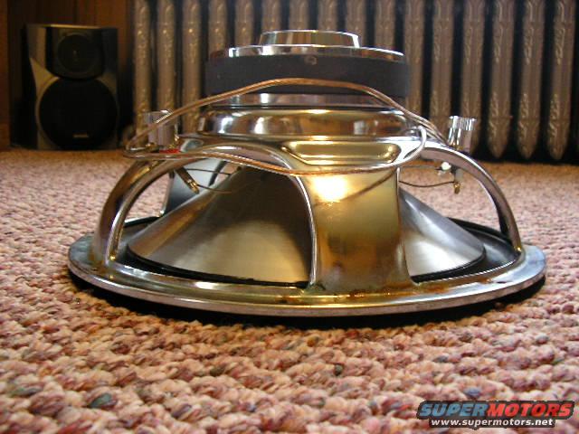 Speaker with chrome basket and black cone on carpet
