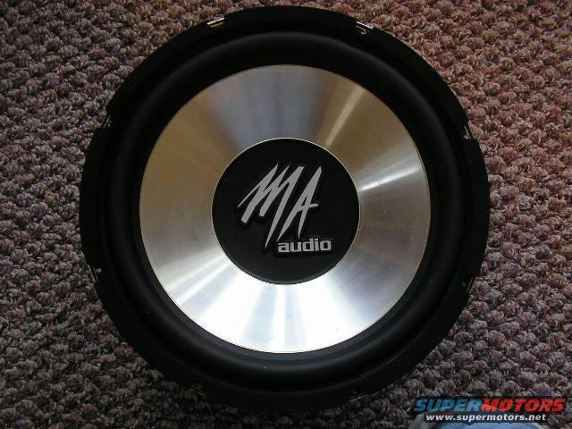 MA Audio subwoofer with silver cone and black surround, resting on carpet