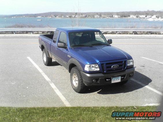 Blue 2006 Ford Ranger parked in a lot with a body of water in the background