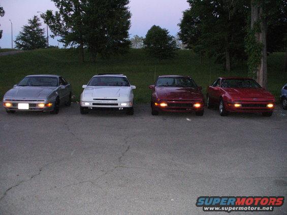 Four 1991 Ford Probes parked in a row, two red, one white, one silver