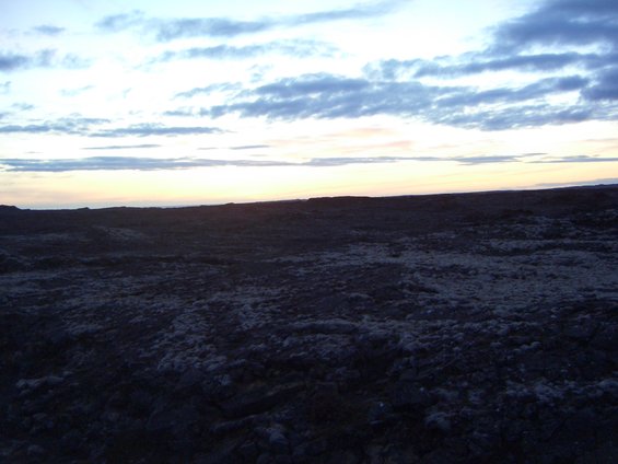 Rocky ground under a cloudy sky at sunset