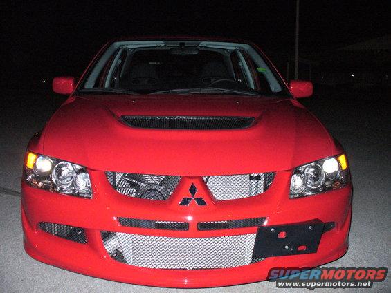 Red Mitsubishi Lancer Evolution front view, aftermarket grille, hood scoop, and headlights