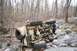1969 Ford Bronco - An off-road vehicle has rolled onto its side in a challenging, rocky terrain with trees all around.