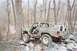 1969 Ford Bronco - A camouflaged pickup truck navigates a challenging rocky obstacle course in a wooded area.