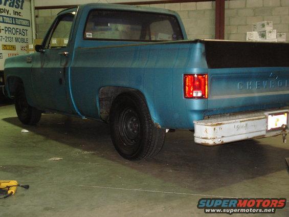 Rear 3/4 view of a blue pickup truck, possibly from the 1970s