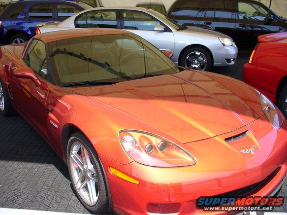 Orange sports car front view with other cars behind