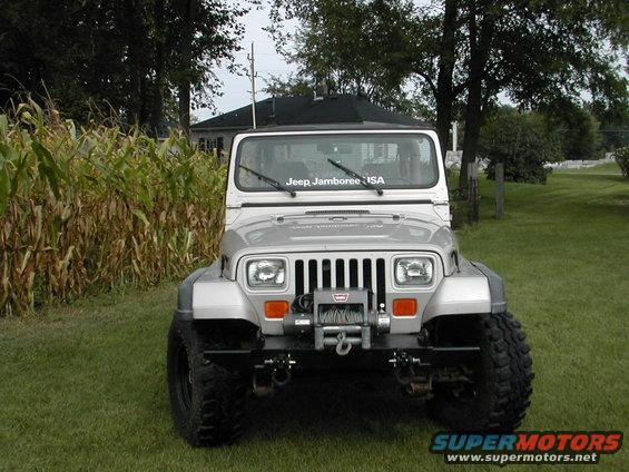 Silver Jeep Wrangler with winch and off-road tires parked on grass