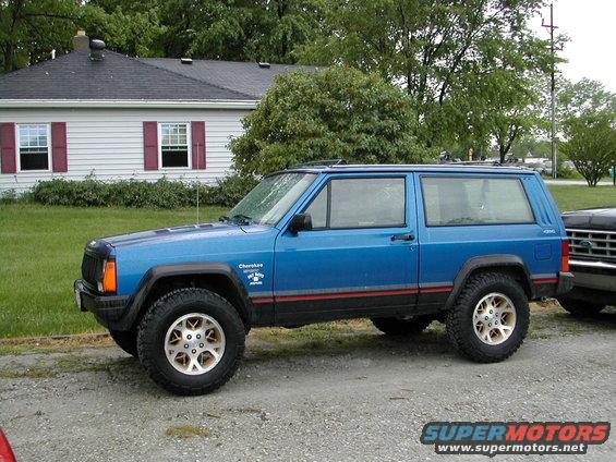 Blue Jeep Cherokee side view with red stripe and 'Cherokee Chief' decal