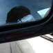 1999 Ford Crown Victoria - Reflection of a person is visible in the side window of a car, with a red reflector strip on the door frame.
