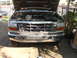 1992 Ford F-350 - The front grille and headlights of a 1992 Ford F-350 are visible, with the hood open to reveal the engine compartment.