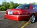 2000 Mercury Grand Marquis - A red 2000 Mercury Grand Marquis sedan is shown from the rear quarter angle, parked on asphalt with yellow lines on asphalt.