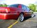 2000 Mercury Grand Marquis - The rear quarter of a red 2000 Mercury Grand Marquis is shown in a parking lot.