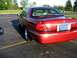 2000 Mercury Grand Marquis - Rear view of a red 2000 Mercury Grand Marquis parked in an asphalt lot with yellow lines.
