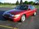 2000 Mercury Grand Marquis - Red 2000 Mercury Grand Marquis sedan parked in a lot with trees and grass in the background.