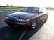 2000 Mercury Grand Marquis - A maroon 2000 Mercury Grand Marquis sedan is parked in a lot under the afternoon sun.