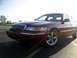2000 Mercury Grand Marquis - A maroon 2000 Mercury Grand Marquis is parked on asphalt under a bright sky.